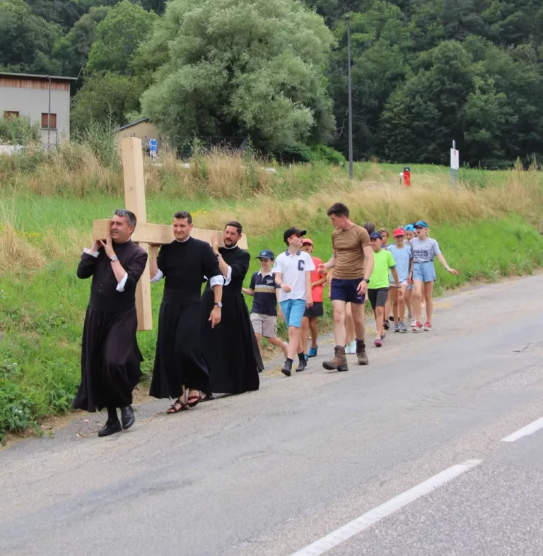 Prêtres et jeunes portant une croix