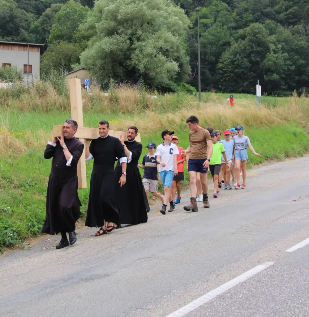 Prêtres et jeunes portant une croix