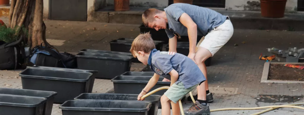un enfant remplit un bac d'eau