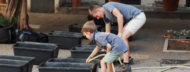 un enfant remplit un bac d'eau